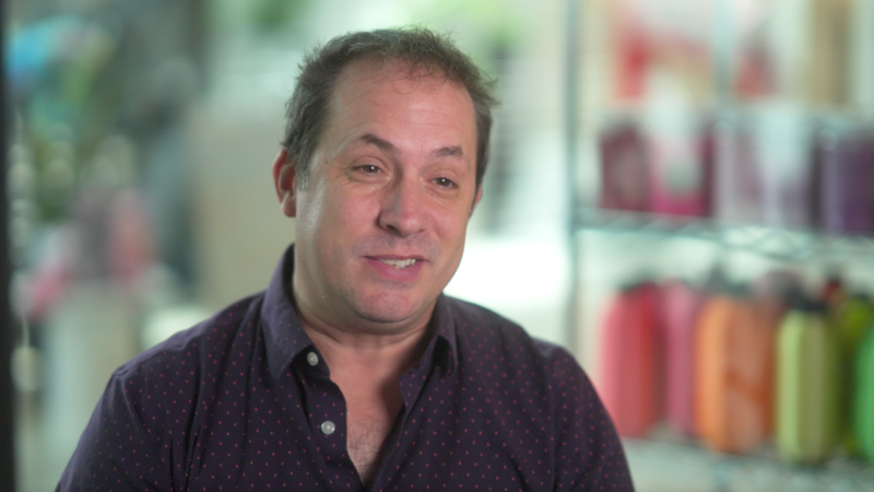 Michael R smirking as he speaks during an interview